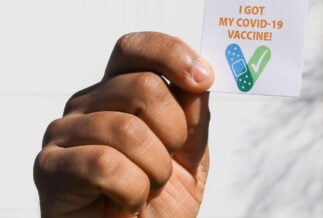 A US army soldier holds up an 'I got the COVID-19 vaccine' sticker.