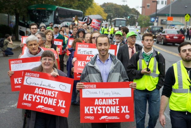 A group of protesters opposing the Keystone XL pipeline hold placards in Boston.