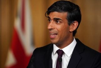 Close up photo of UK prime minister Rishi Sunak giving speech in front on Union Jack flag.