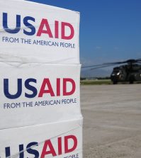 USAID pallets Pallets of USAID-supplied food, water and supplies sit on the flight line at the airport as a MH-53E helicopter awaits to be on loaded with supplies. Carl Vinson and Carrier Air Wing 17 are conducting humanitarian and disaster relief operations
